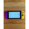 Nintendo Switch console with purple and yellow Joy-Con on a wooden surface