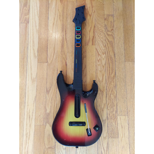 Gaming guitar with colorful buttons on a wooden floor