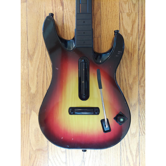 Gaming guitar with colorful buttons on a wooden floor