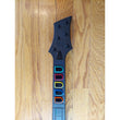 Black guitar neck with colorful inlays on a wooden surface