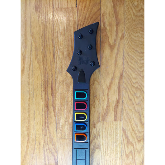 Gaming guitar with colorful buttons on a wooden floor